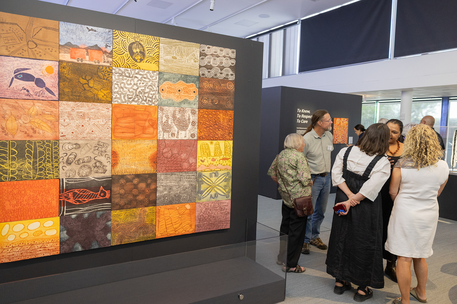 絵の展示の前で会話をする男女