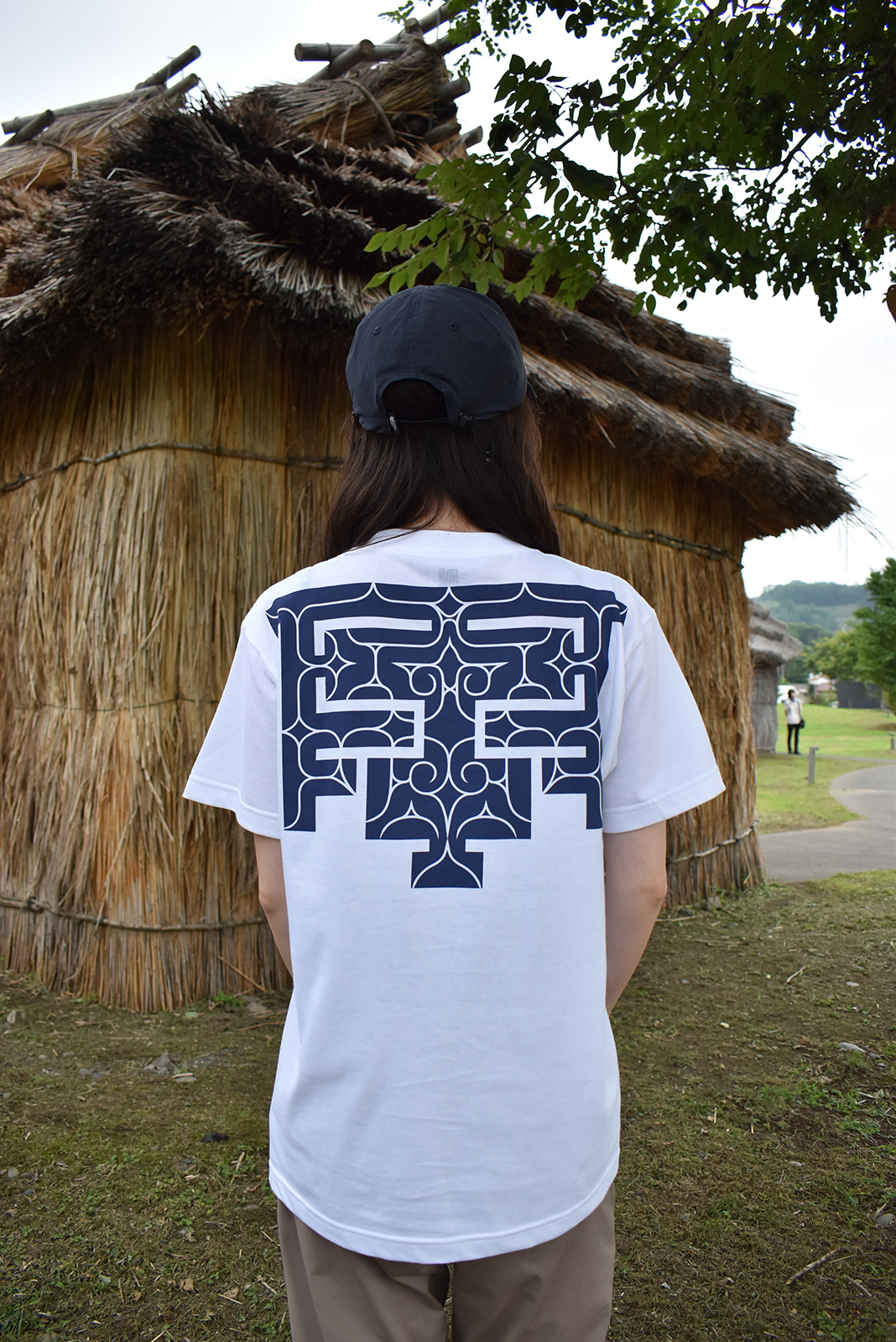 紺色のアイヌ文様が入った白いTシャツ