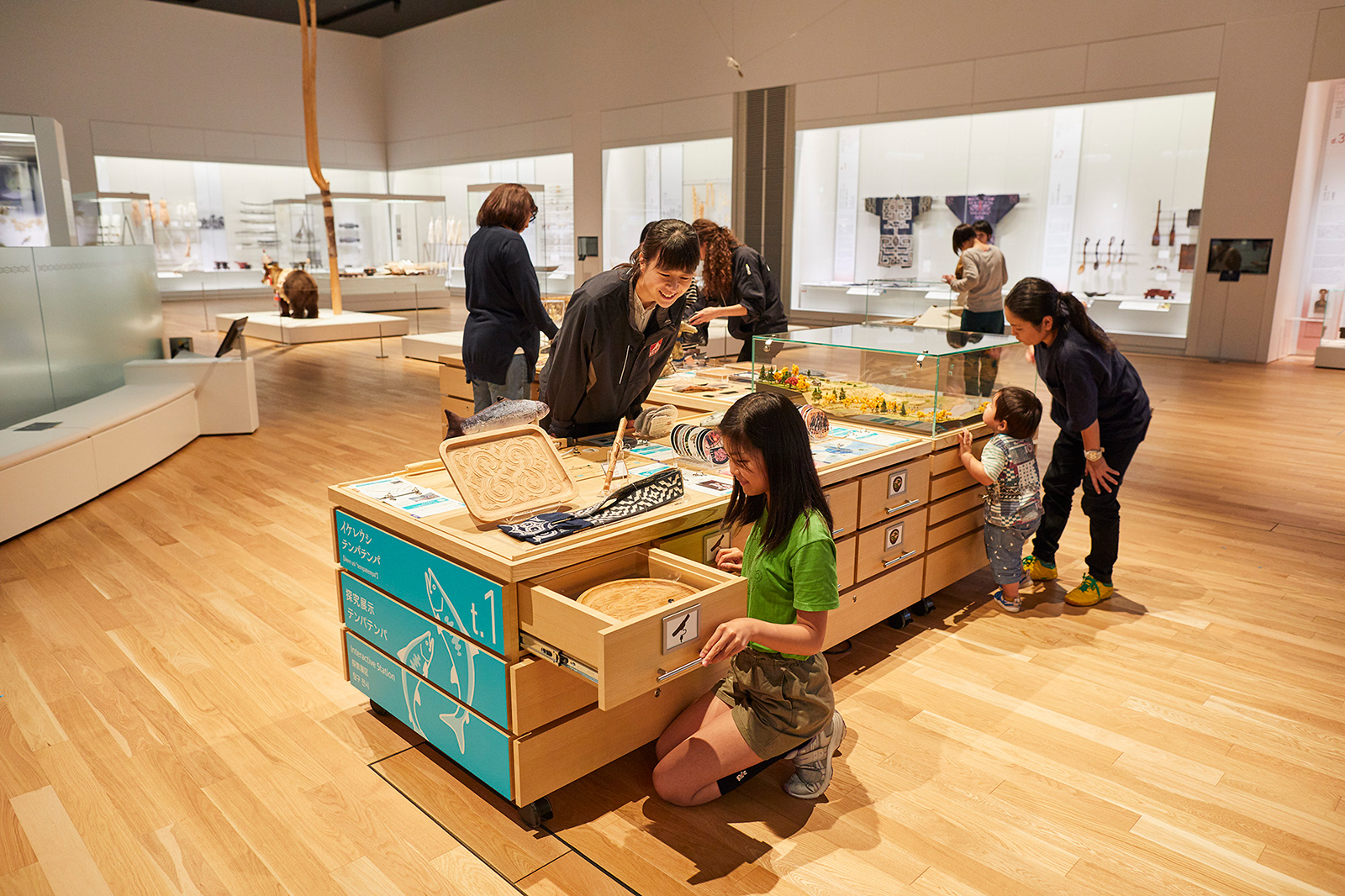 国立アイヌ民族博物館展示室の職員と子どもの来館者
