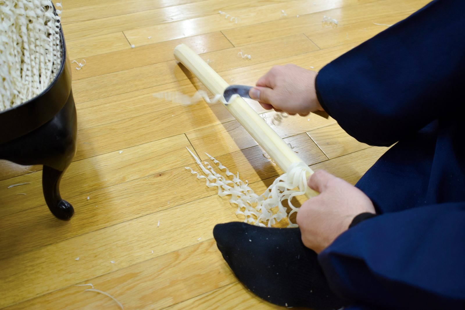 刃物を使い木の棒を削る手元