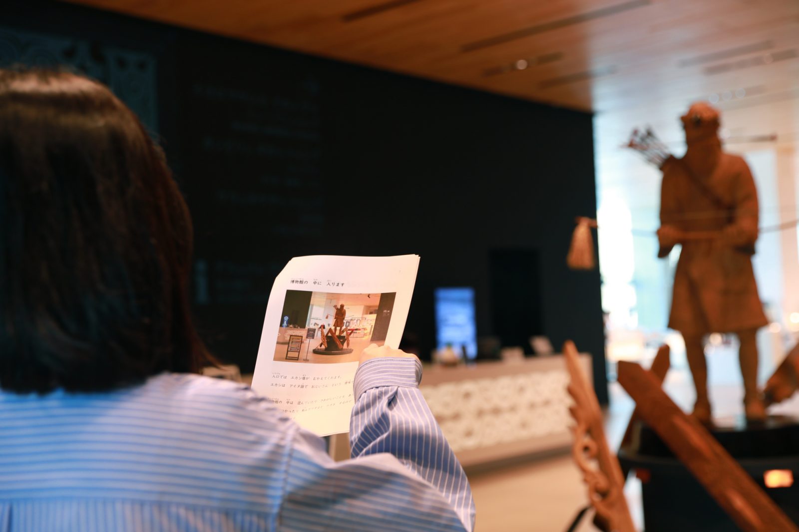 博物館ロビーであんしんガイドを手に持つ来館者